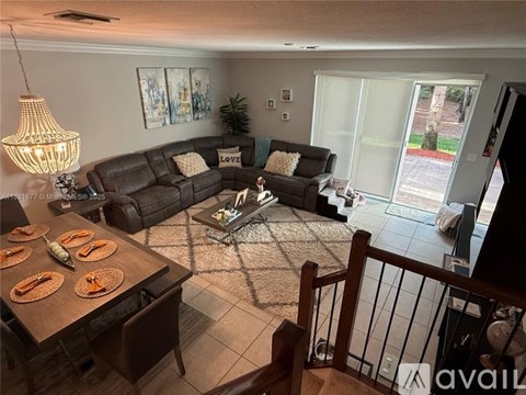 A living room with a brown couch and a glass coffee table.