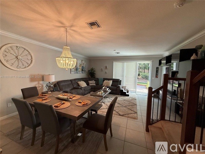 A dining room with a table set for six and a couch in the background.