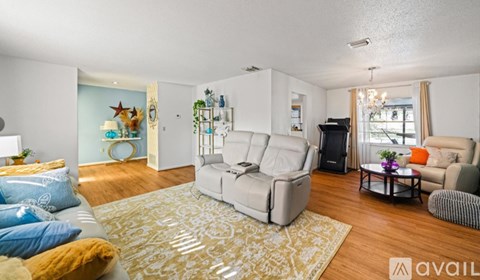 A living room with a white sofa and a rug.