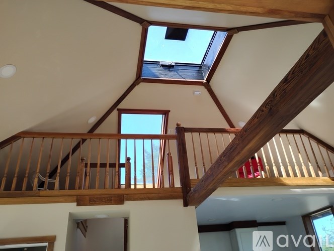 A wooden staircase with a skylight above it.