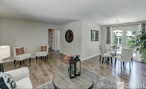 A living room with a white couch, a coffee table, and a dining table with chairs.