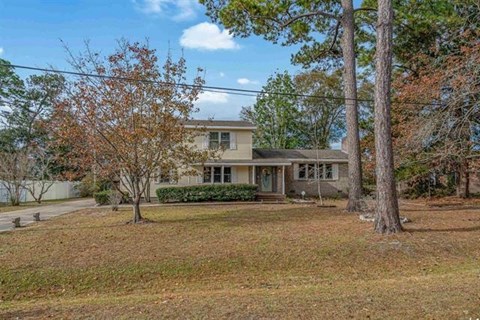 A house with a tree in front of it.