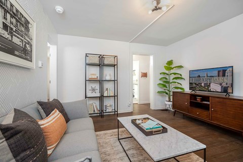 A living room with a grey couch and a coffee table with a book on it.