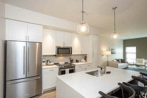 A modern kitchen with a stainless steel refrigerator and white countertops.