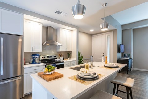 A modern kitchen with a stainless steel refrigerator and a breakfast setting on the counter.