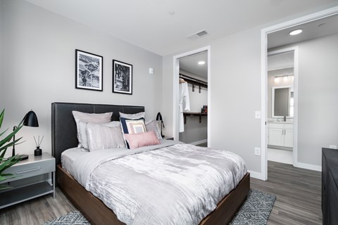A bedroom with a large bed and a mirror on the wall.