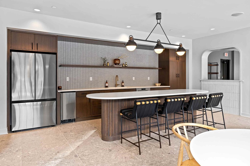 A modern kitchen with a bar area and a refrigerator.