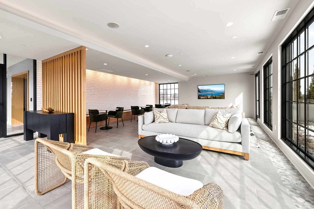 A modern living room with a black coffee table and a white sofa.