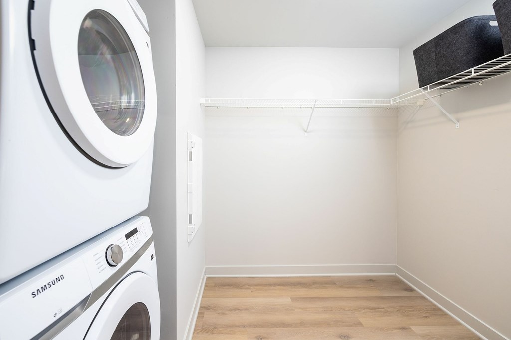 A white Samsung washing machine and dryer in a small laundry room.