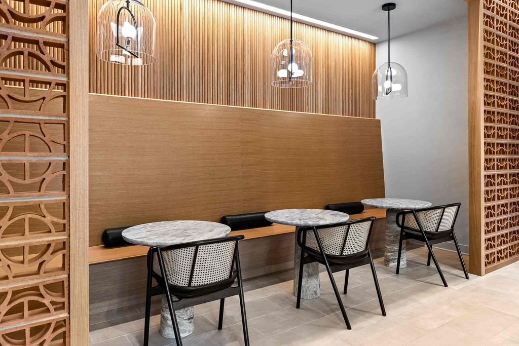A wooden panelled wall with two chairs and a table in front of it.