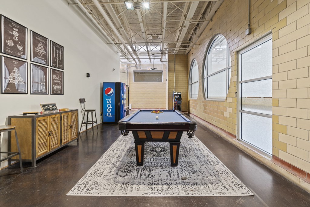 a game room with a pool table and a vending machine