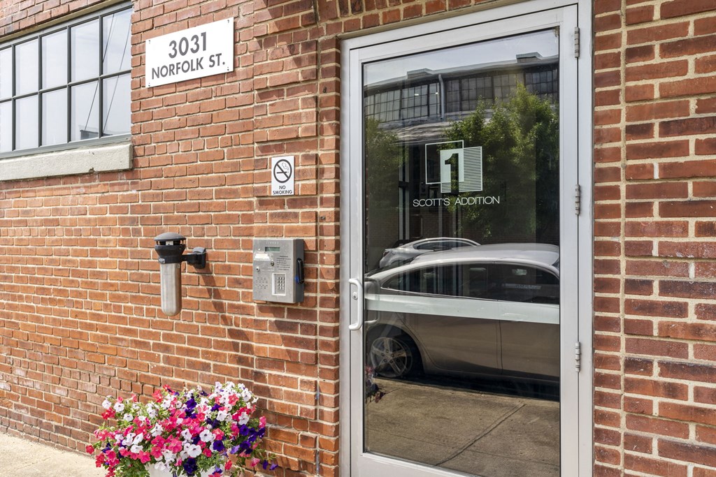 a brick building with a glass door and a car reflected in the window