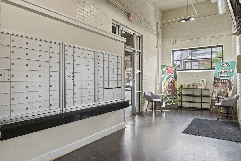 a wall of lockers in a room with tables and chairs