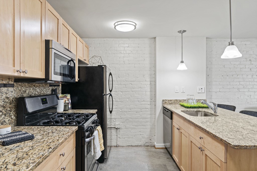 a kitchen with granite counter tops and black appliances