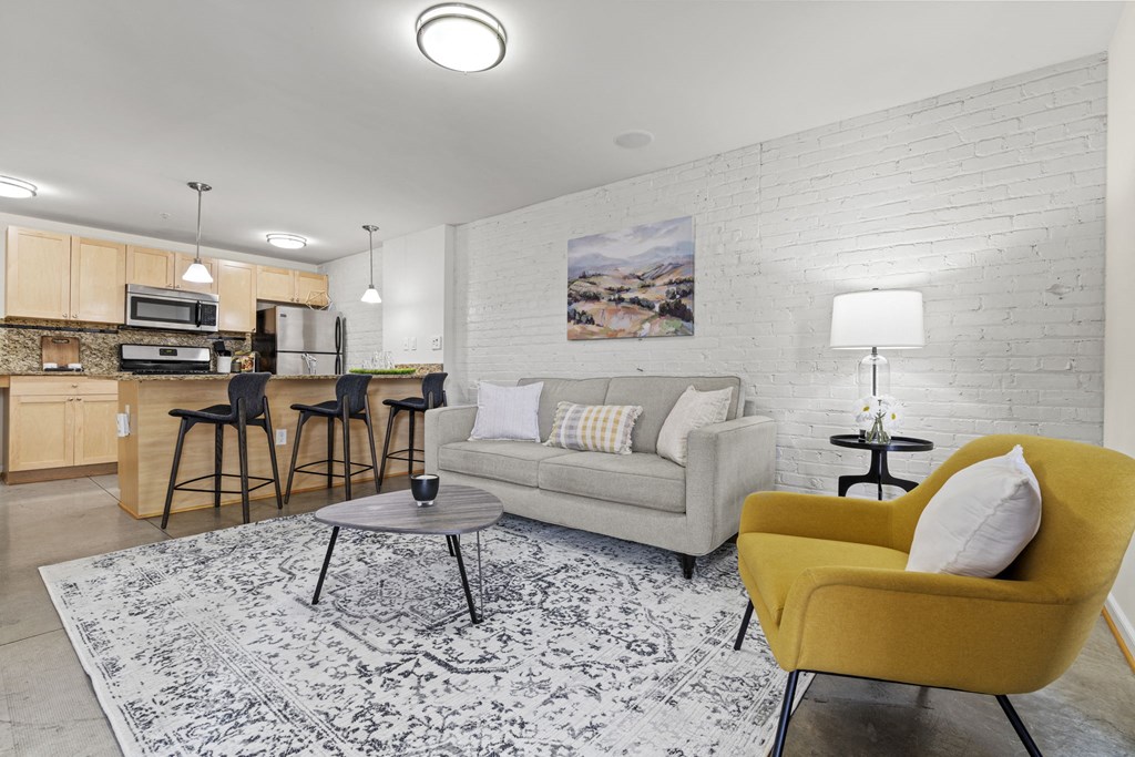 a living room with a couch and a chair and a kitchen