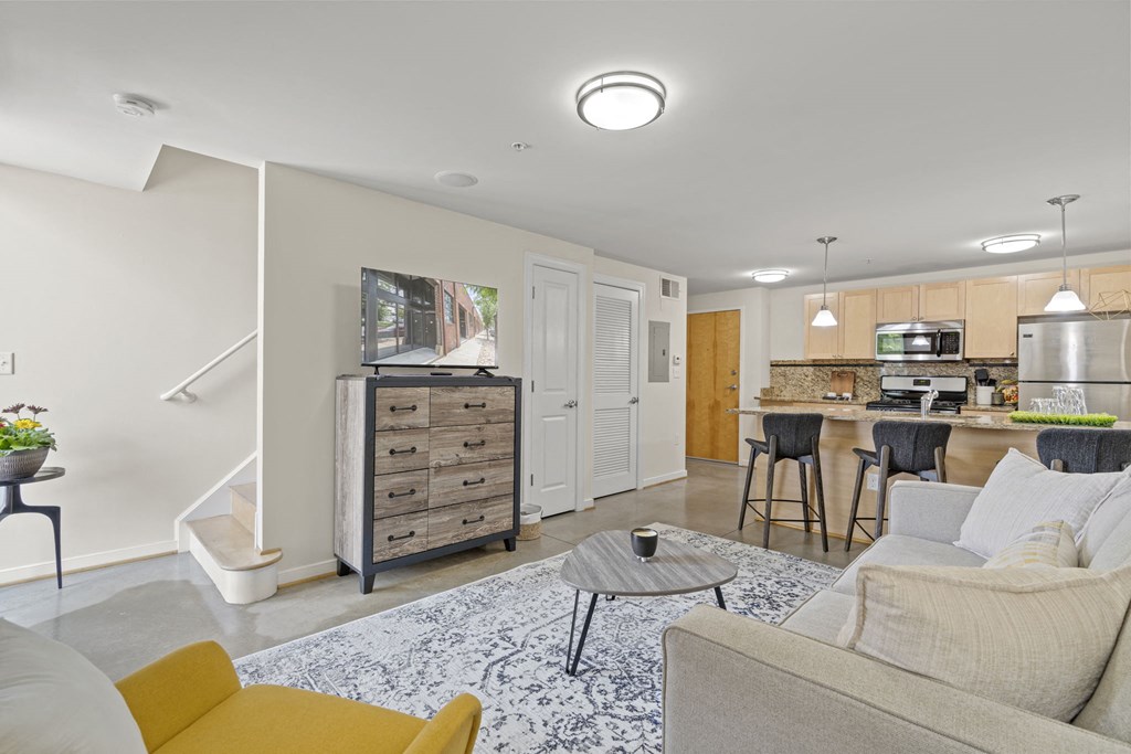 a living room and kitchen with a couch and a table