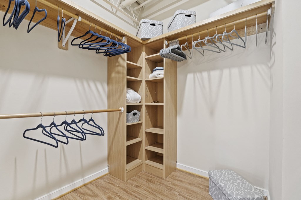 a walk in closet with shelves and hangers with shoes