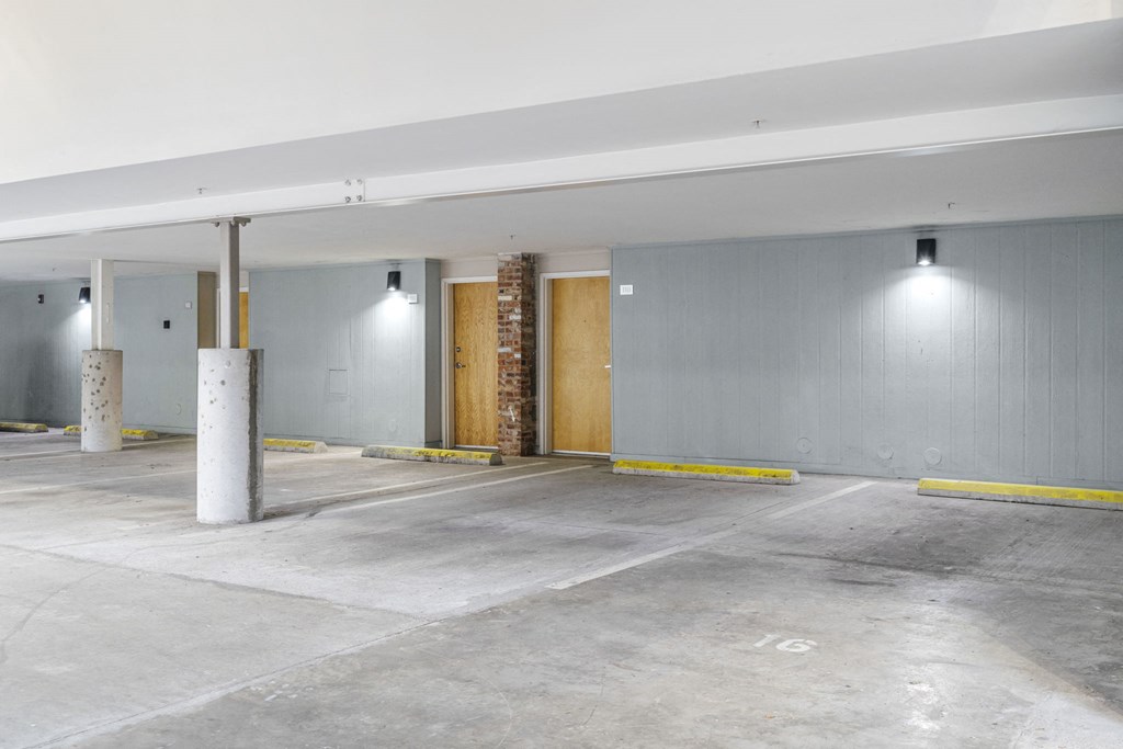 the interior of a parking garage with grey walls and a wooden door