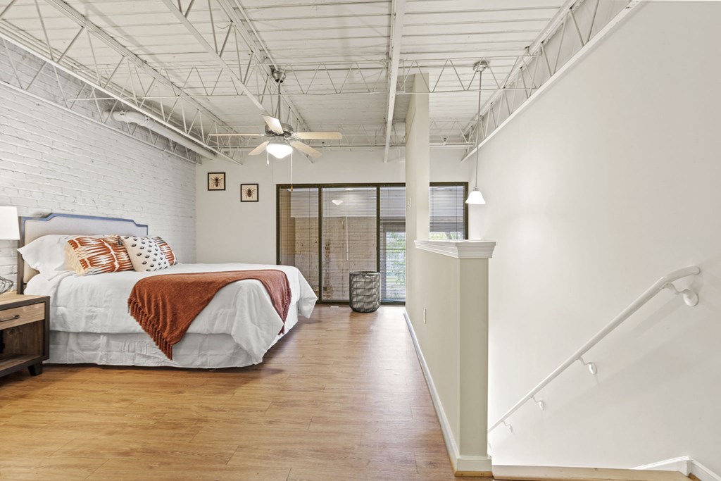 a bedroom with a bed and a white brick wall