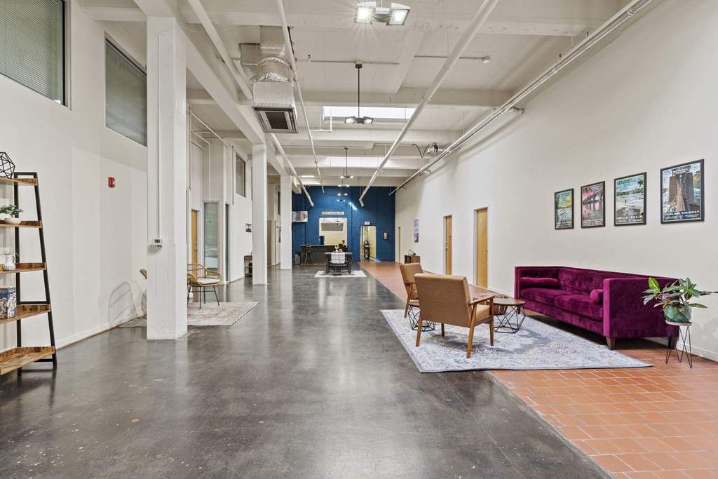 a long hallway with couches and chairs and paintings on the walls