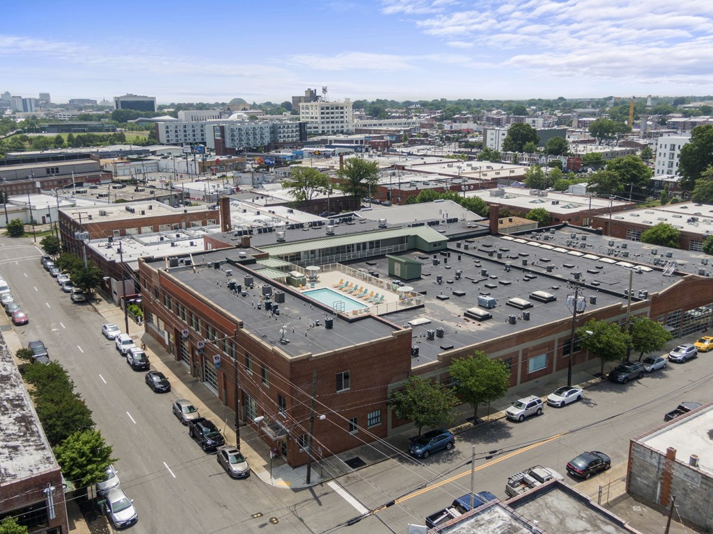 an aerial view of a city with a building and parking lot