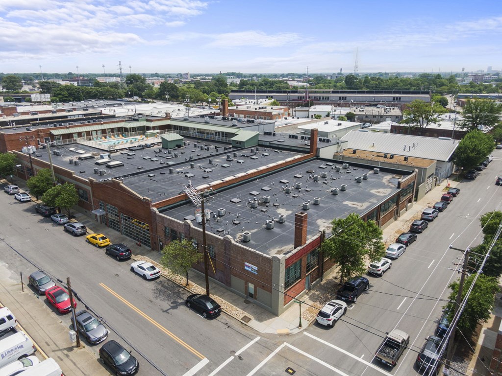 an aerial view of a building with a parking lot and cars parked