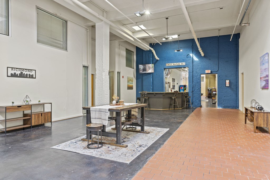 a room with a desk and a table in the center of it