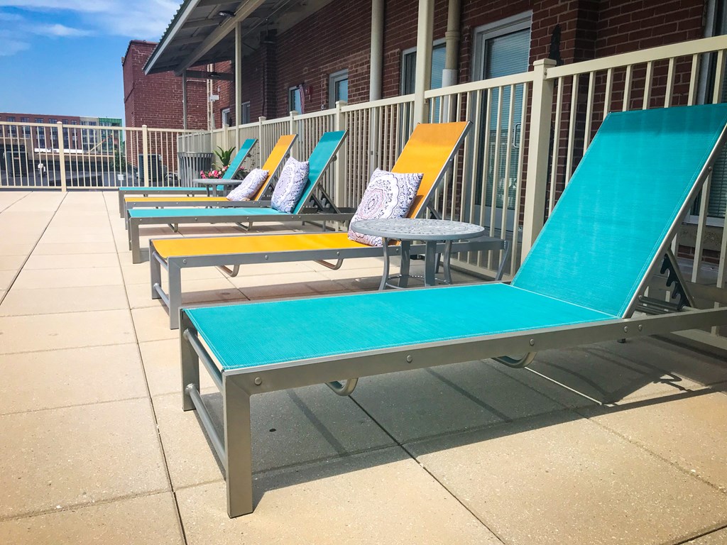 a row of blue and yellow lounge chairs and a table