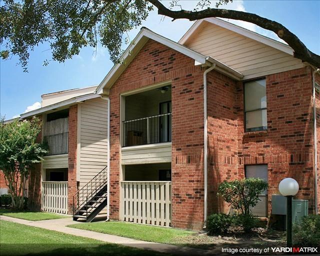 a brick apartment building with stairs and a tree