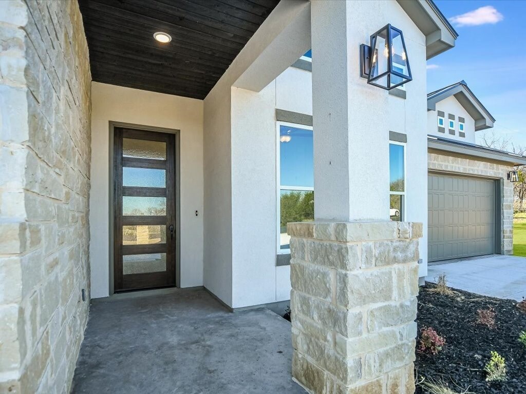 A modern house with a stone pillar and a wooden ceiling.