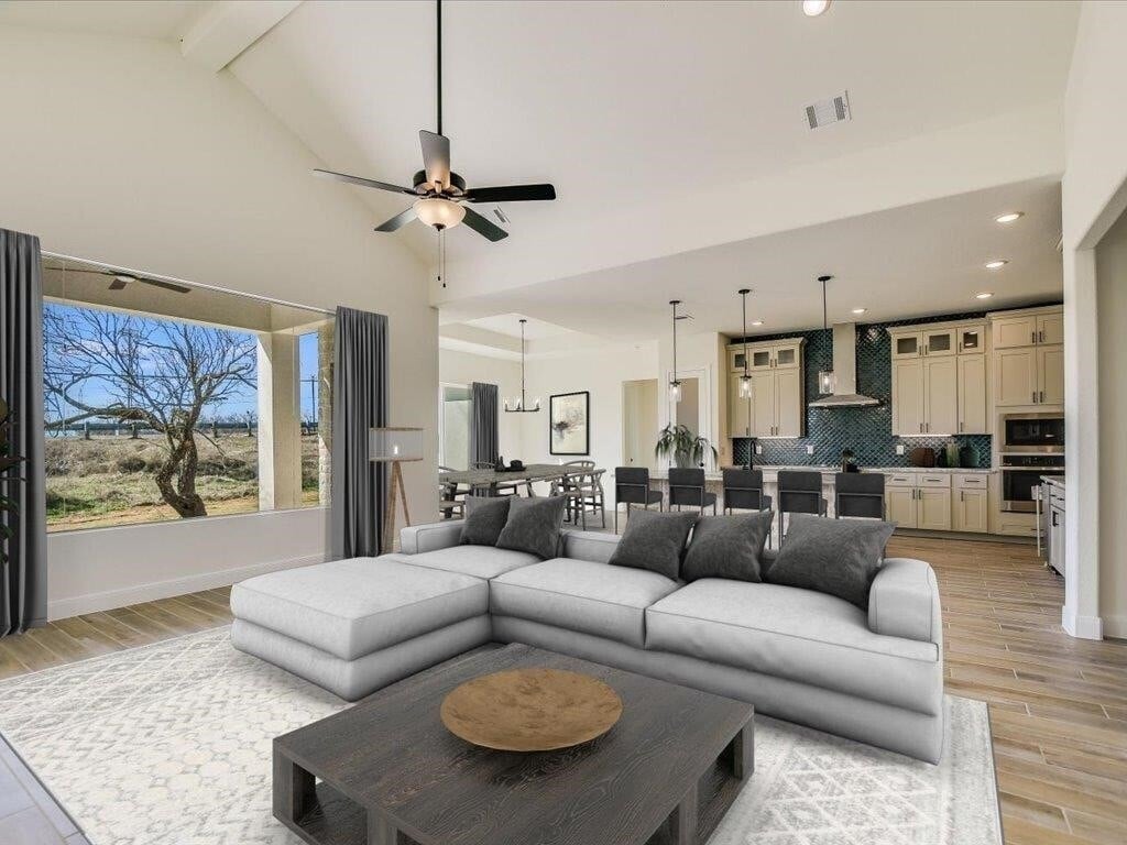 A modern living room with a large sectional sofa and a coffee table in the center.