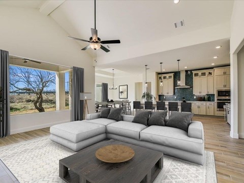 A modern living room with a large sectional sofa and a coffee table in the center.
