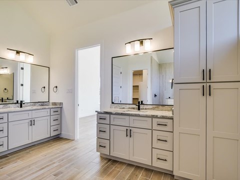 A spacious bathroom with a vanity and double sinks.