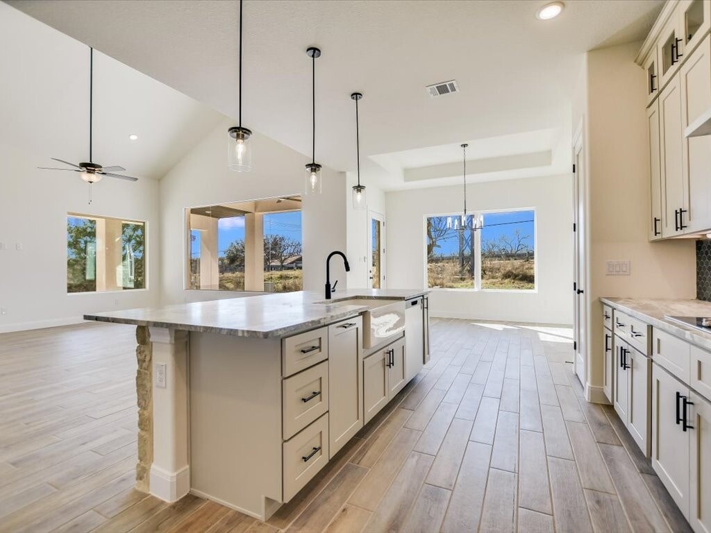 A spacious kitchen with a large island and pendant lights.