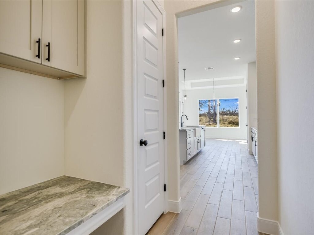 A kitchen with a marble countertop and white cabinets.