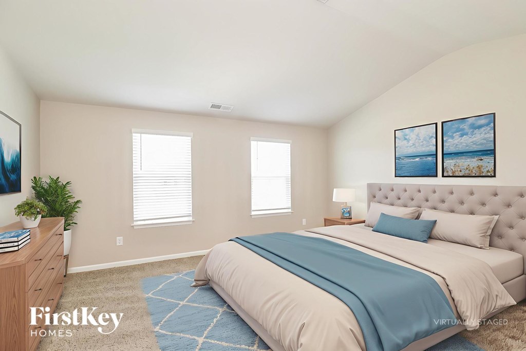 A bedroom with a large bed and a painting on the wall.