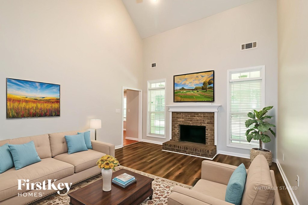 A living room with a fireplace and a painting on the wall.