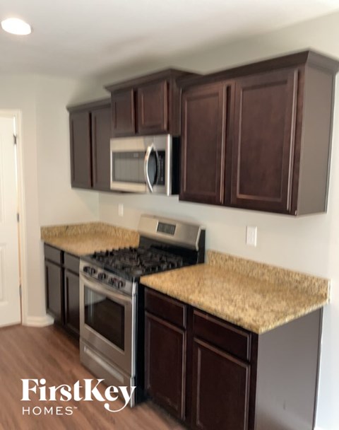 A kitchen with brown cabinets and a granite countertop.