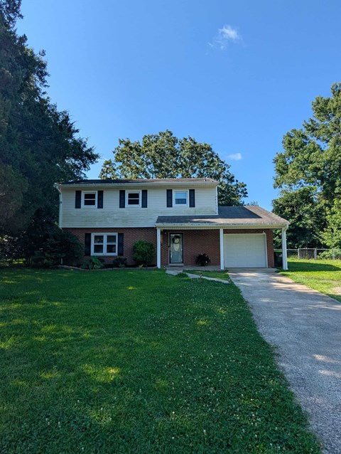 A house with a garage and a driveway in front.