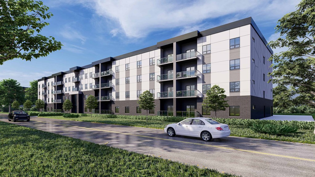 A modern apartment building with cars parked in front.