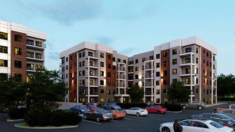 A parking lot with cars and apartment buildings.