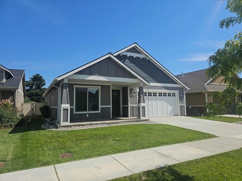 A house with a grey roof and a white garage door.