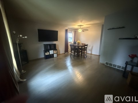 A living room with a television, a dining table with chairs, and a fireplace.
