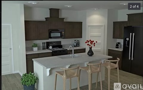 A kitchen with a white island and wooden chairs.