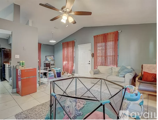 A living room with a ceiling fan and a glass table.