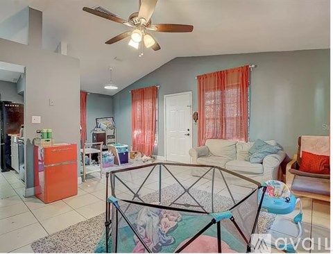 A living room with a ceiling fan and a glass table.