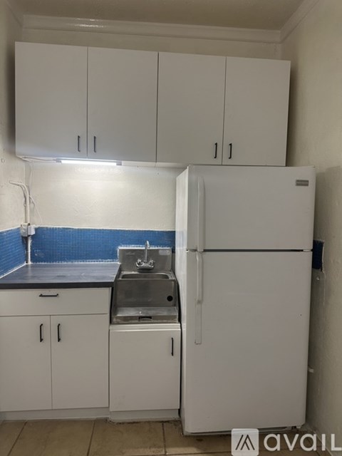 A small kitchen with a sink and a refrigerator.