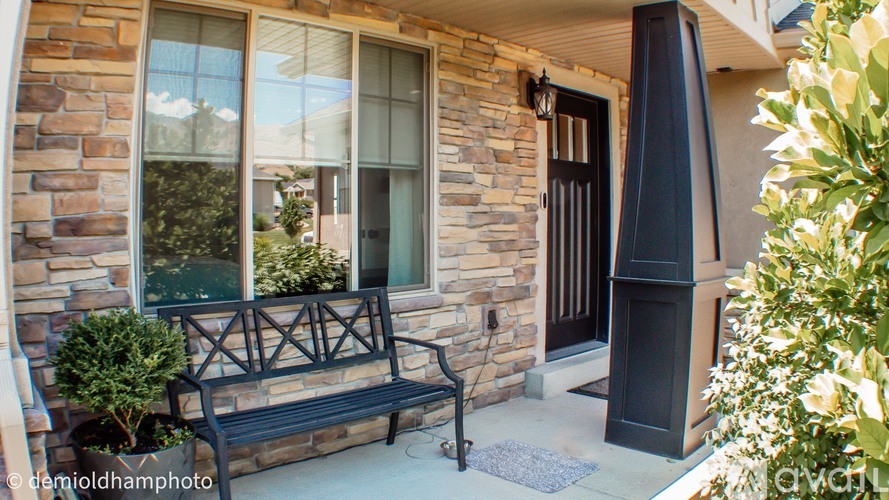 A house with a black bench in front of it.