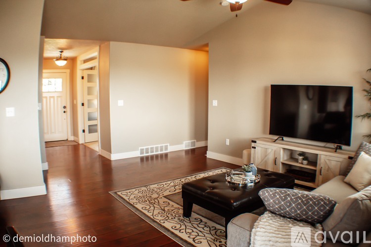 A living room with a couch, coffee table, and television.