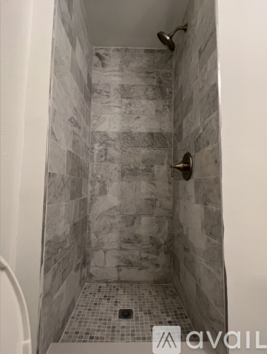 A bathroom with a towel hanging on the wall and a mirror above the sink.